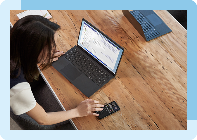 a view of a man and woman sitting in chairs working on a laptop on a desk